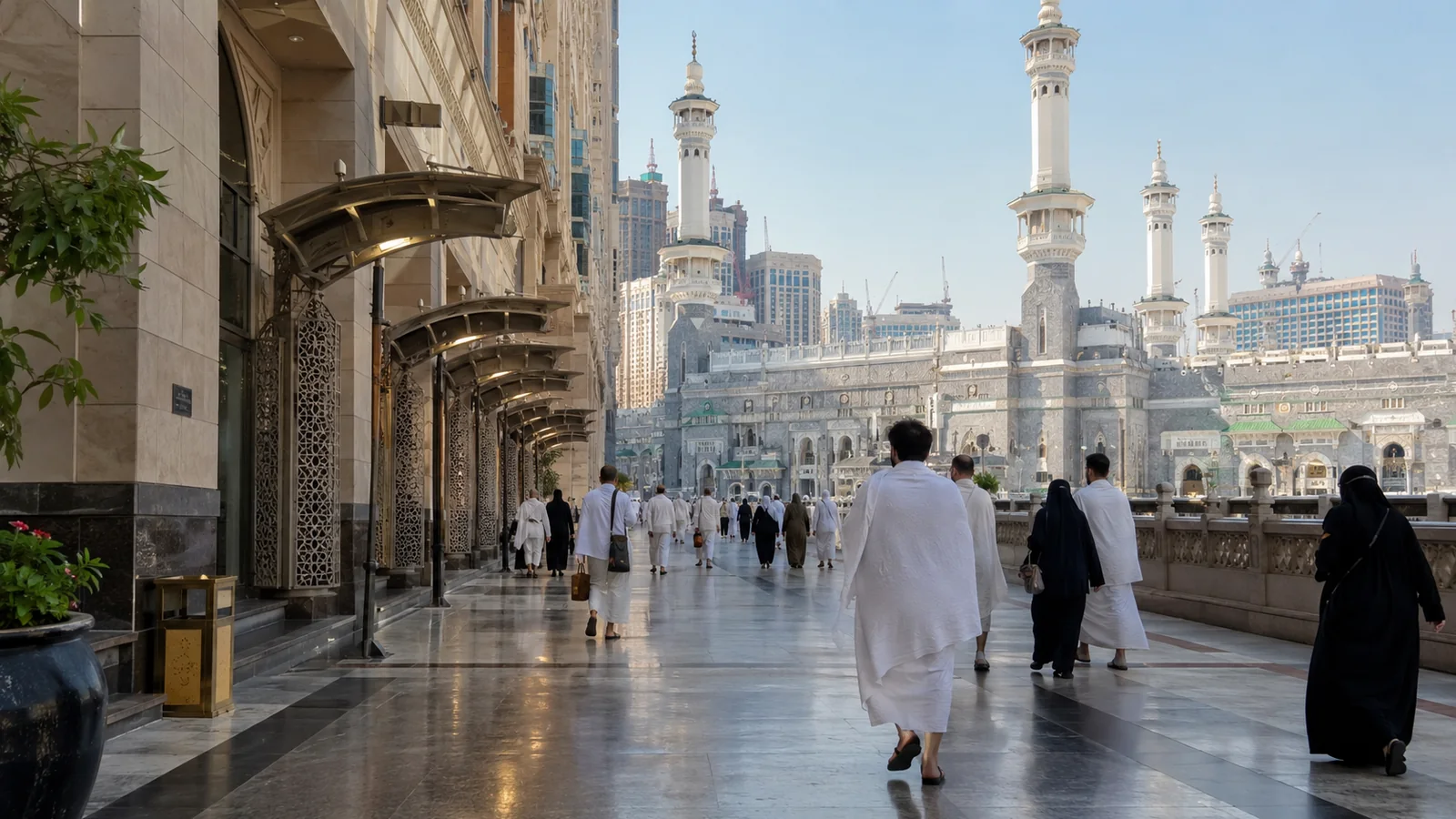 Pilgrims walking from a hotel-side promenade toward Masjid al-Haram.
